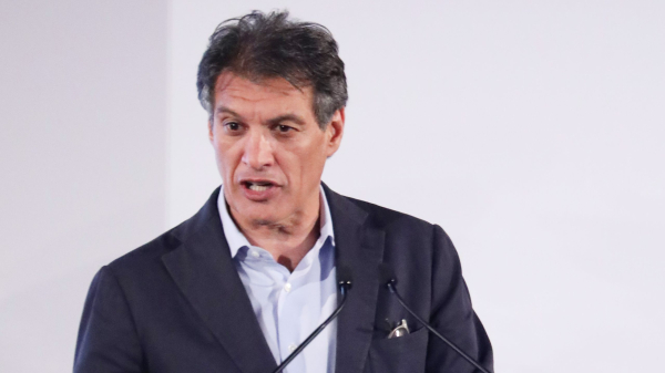 Hairstylist Frederic Fekkai speaking at a podium at an event.